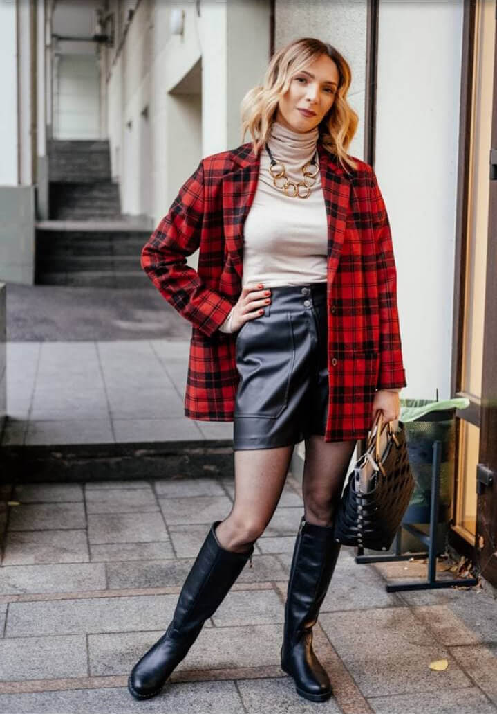 Finished street look with a red checked coat, leather shorts and tall boots