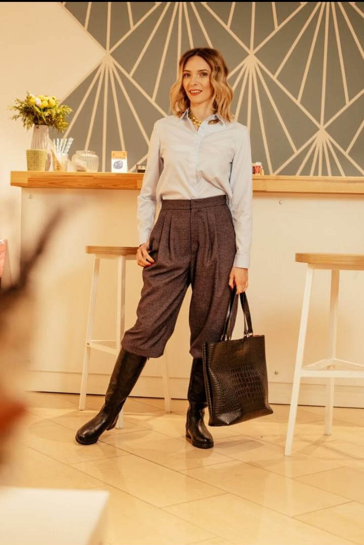 Woman in a light blue shirt, wool trousers and tall boots after a style consultation