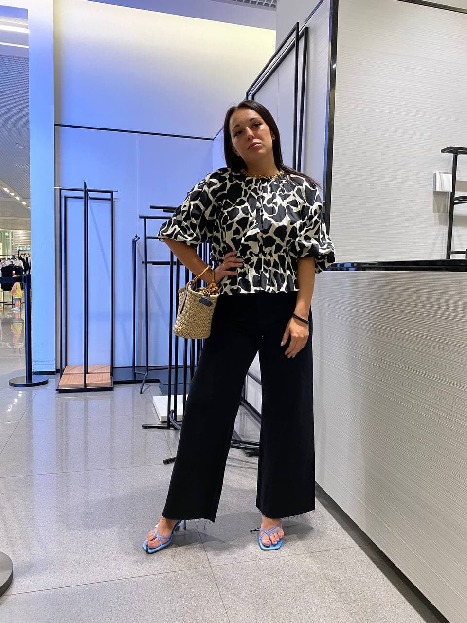 Modern workwear look with a printed blouse and wide black trousers
