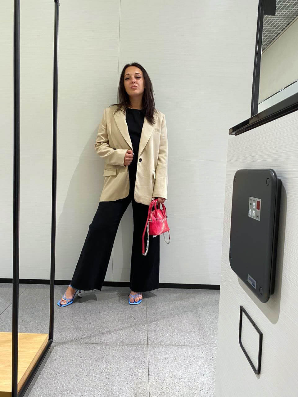 Client in a beige blazer and black trousers with a pink handbag chosen during online shopping